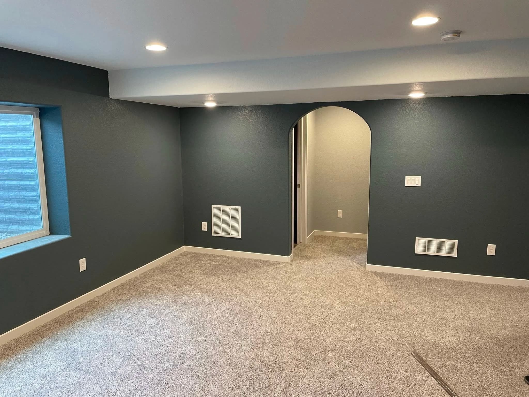 Remodeled living room with gray walls and recessed lighting
