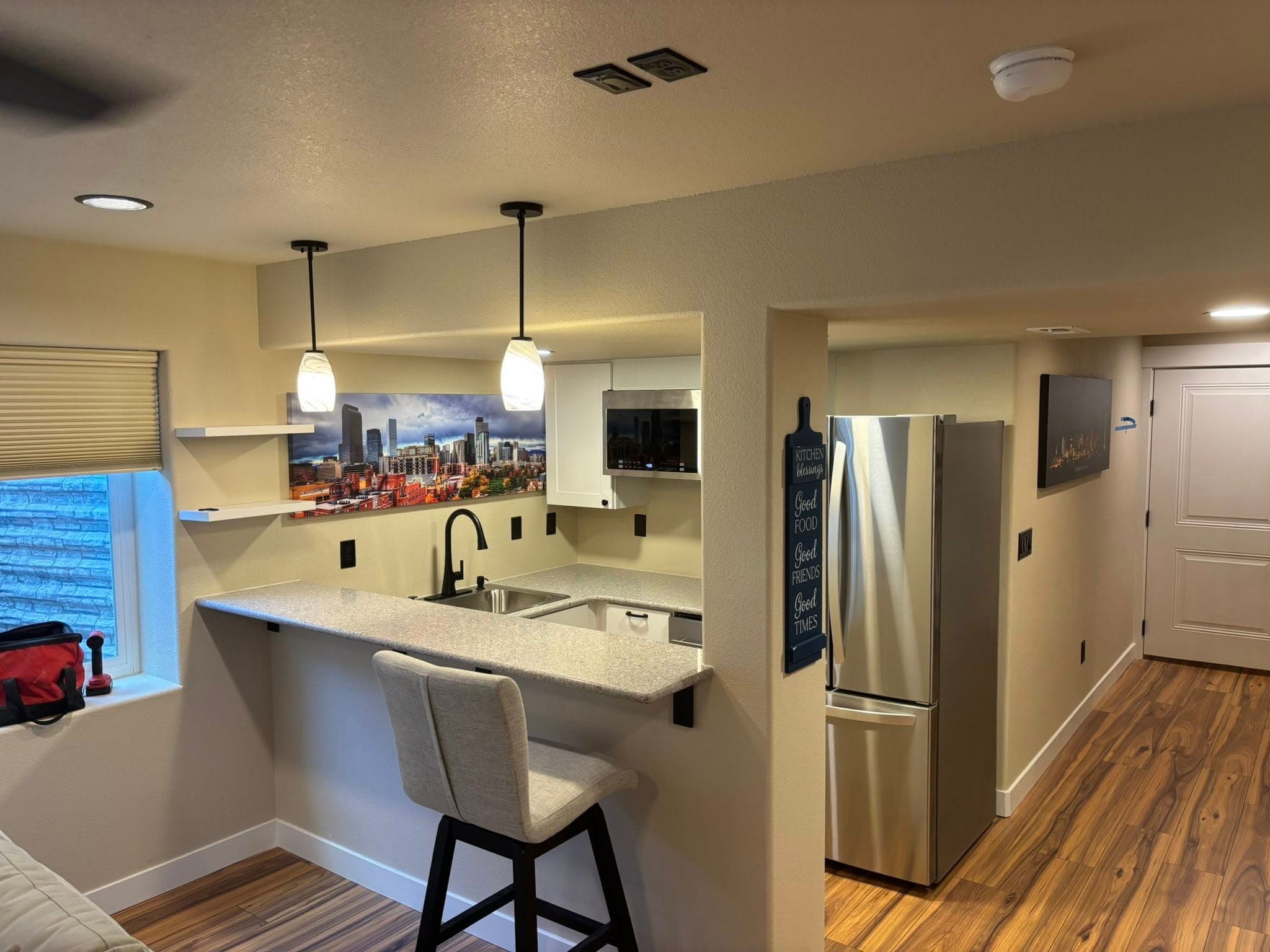 Basement kitchen with white cabinetry and pendant lighting