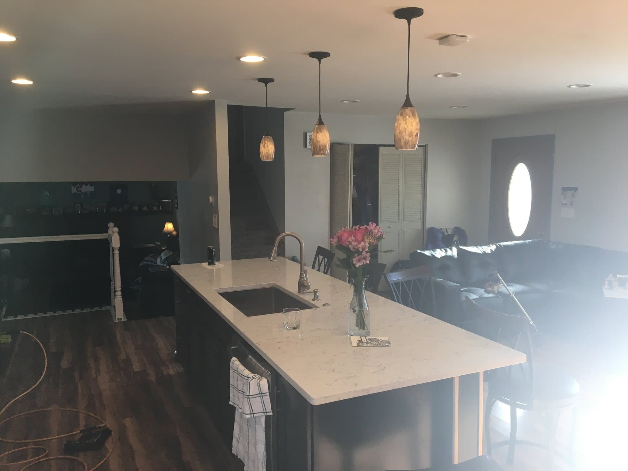 Kitchen island with pendant lighting and dark cabinetry