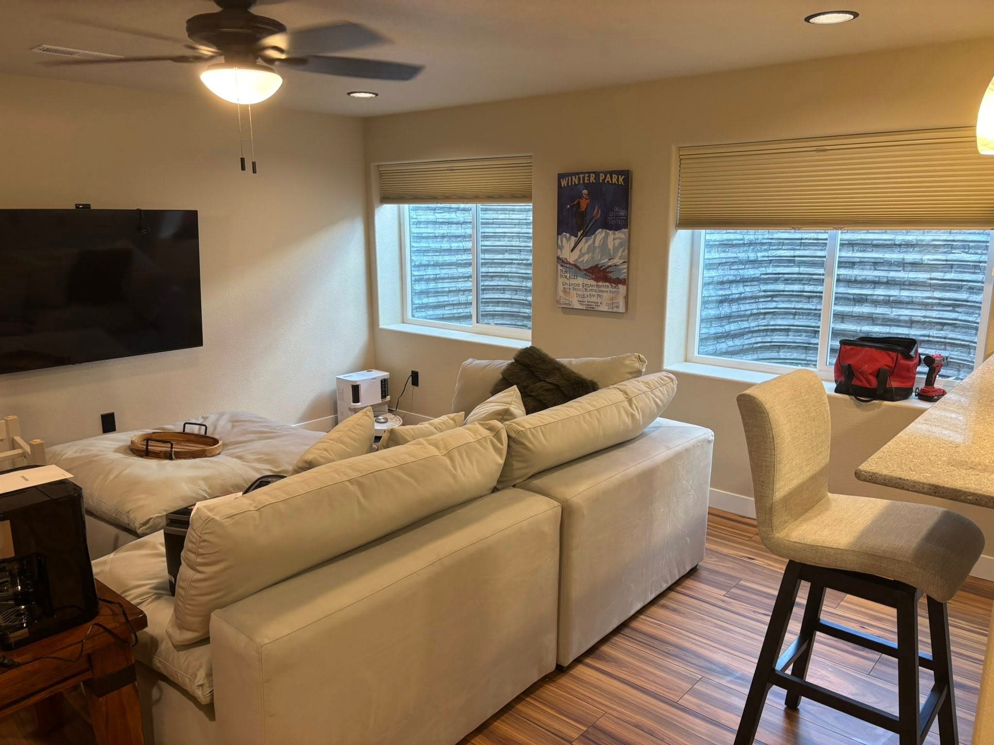 Finished living room with cream sectional and hardwood flooring